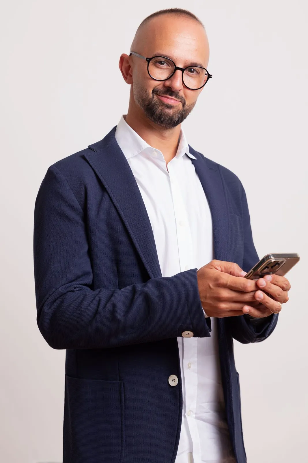 Francesco Di Turo al lavoro con lo smartphone, consulente di marketing digitale, giacca blu.
