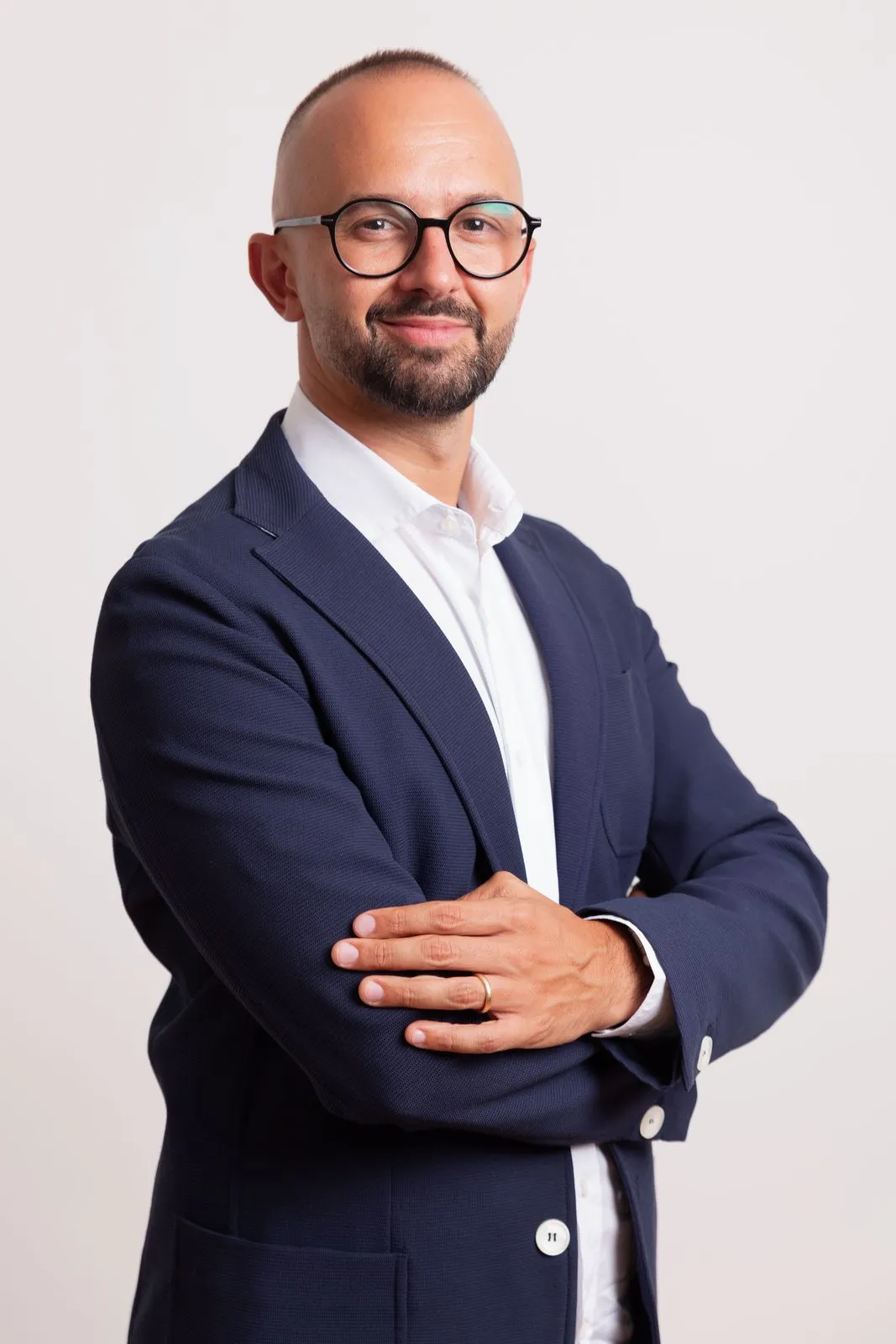 Francesco Di Turo, consulente marketing e comunicazione, sorride in studio con giacca blu su camicia bianca.